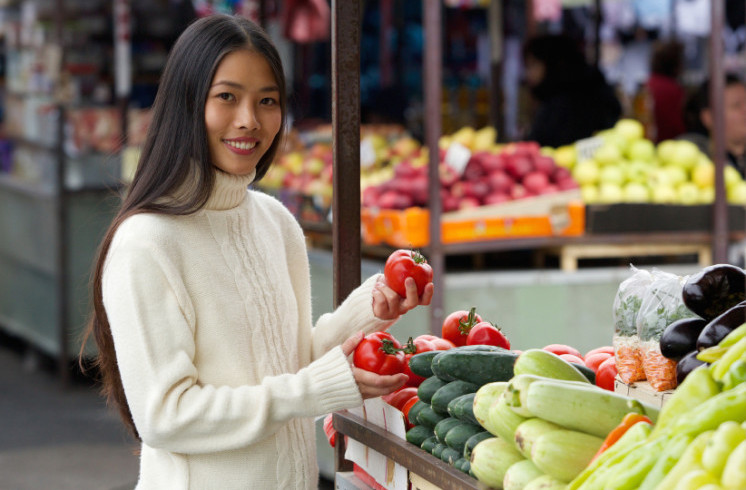 smiling woman at vegetable stand