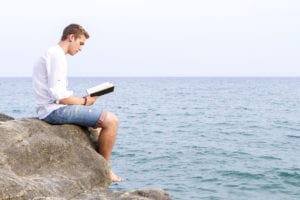 man reading on the beach