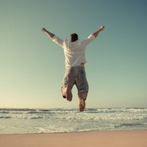 man jumping on beach