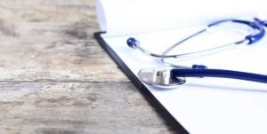 medical history with stethoscope on wooden desk