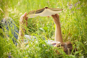reading book in tall grass