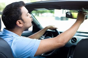 man looking in rearview mirror