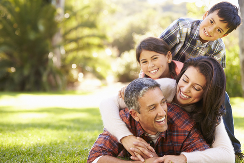 family hugging in grass