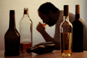 man with several alcohol bottles