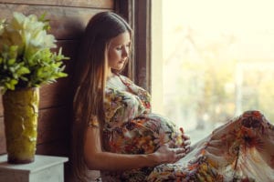 Pregnant woman sitting by window