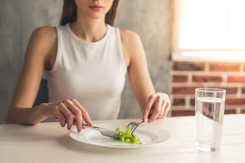 woman slicing celery on plate