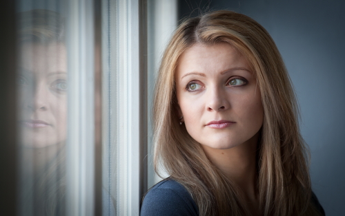 woman looking forlorn out window