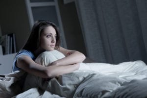 woman with arms crossed in bed