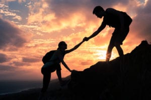 man helping woman climb up