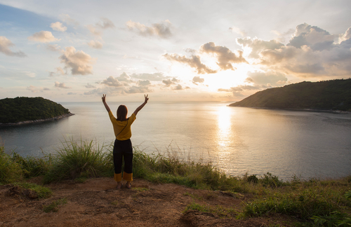 woman facing sunset over lake