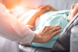 doctors hand on patient sleeping