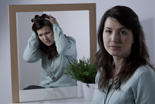 woman with mirror showing different image of her