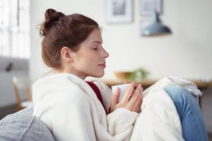 woman having coffee with eyes closed