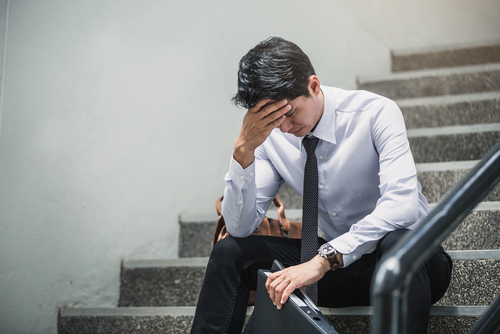 man with head down on stairwell