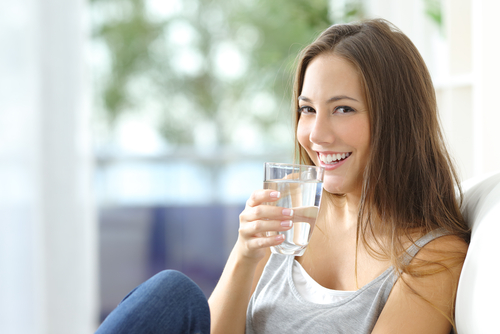 woman smiling and holding water glass
