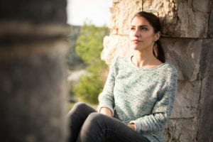 woman leaning on rock wall