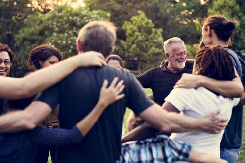 group of people in circle hugging