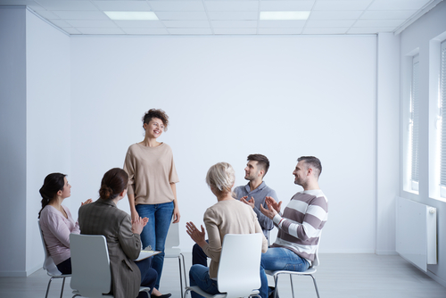 woman standing while group claps