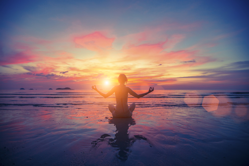 woman on beach in seated meditation