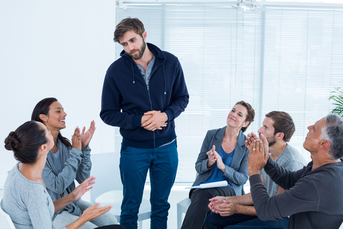 man standing during group therapy