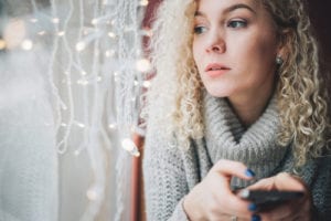 sad woman by Christmas lights