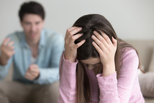 woman with head down as man talks