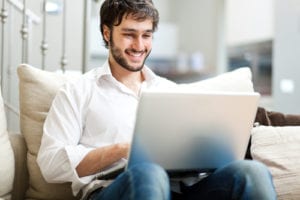 man smiling at laptop