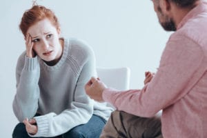 therapy session with woman holding head