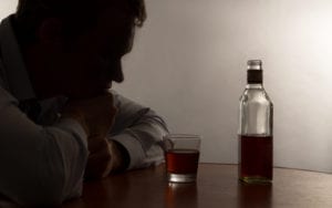 man looking at drink and bottle