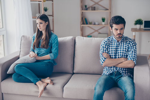couple looking away from each-other on couch