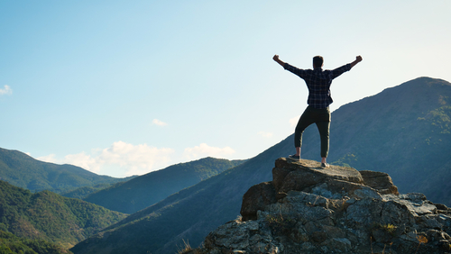 man conquering mountain