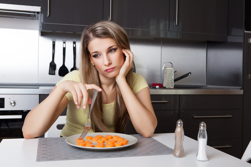 unhappy woman with carrots on plate