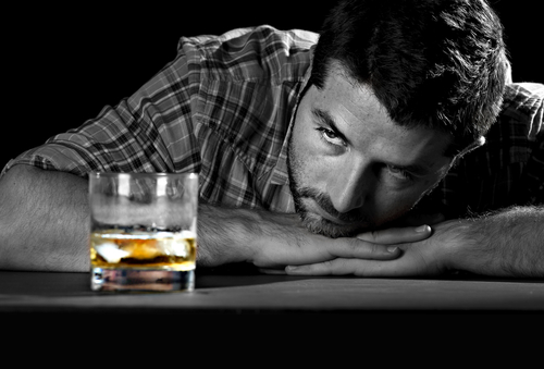 man looking at liquor drink