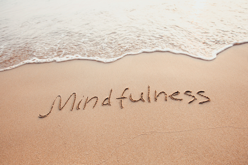 mindfulness written on sand