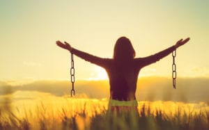 woman breaking chains in sunlight