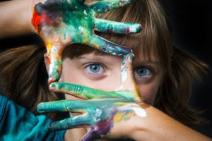 girl with painted hand covering face