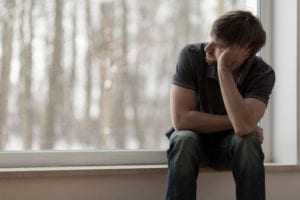 Man looking out window