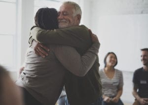 People hugging in group therapy