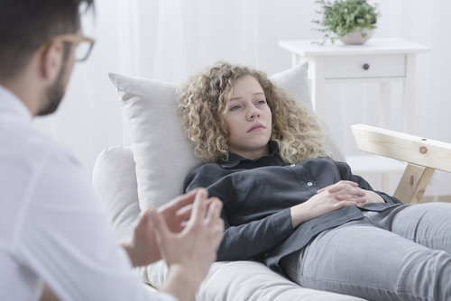 Sad woman on couch with counselor