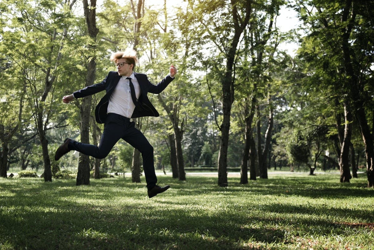 Businessman flying through the park