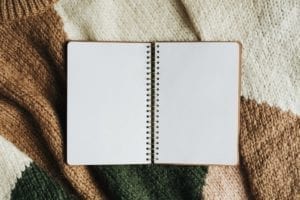Blank opened notebook on a sweater