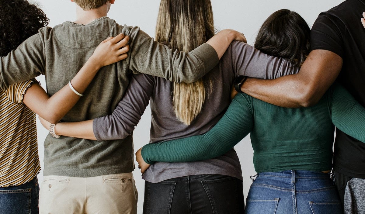 Rearview of diverse people hugging each other