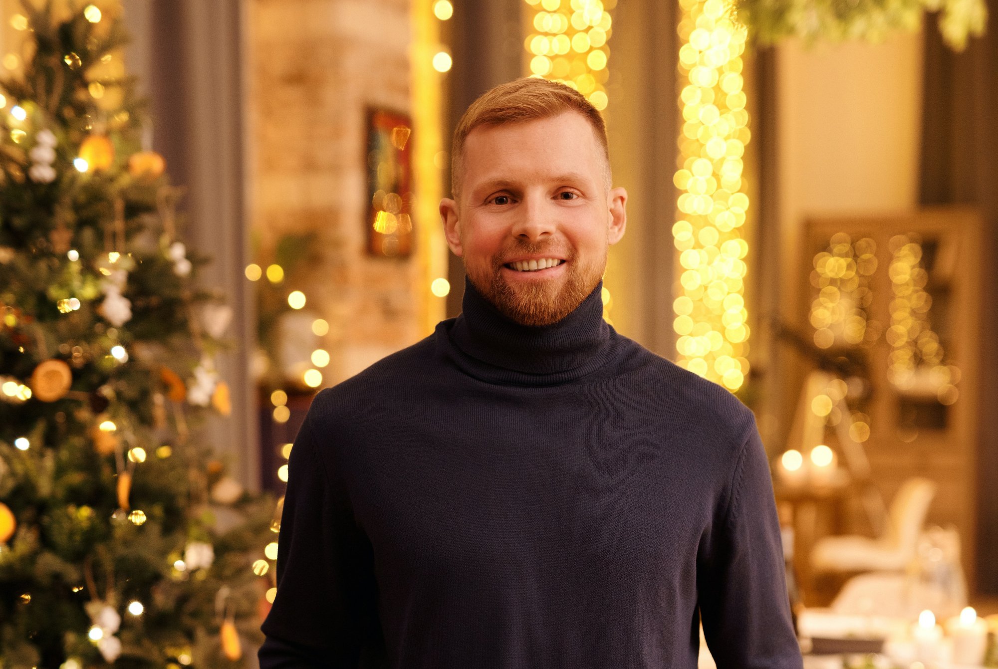 man in black sleeve shirt standing near Christmas tree