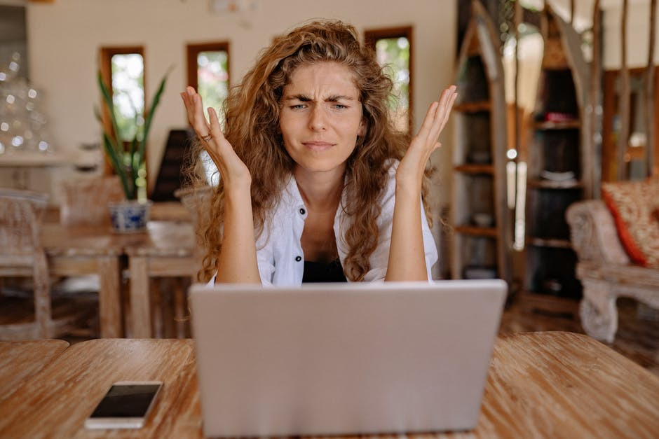 woman spreads her hands in front of laptop