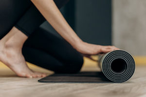 woman unrolls fitness mat