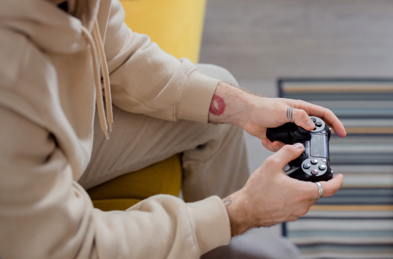 Close up of a person in a hoodie using a game controller