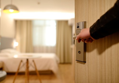 close up of person holding on door lever inside room